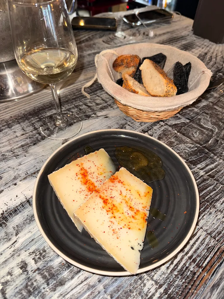 Assiette de fromage, pain et verre de vin nature chez VINOBOBO